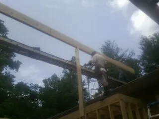 Carpenter setting a ridge beam over a new addition frame — Ice Dam Removal by Roofing Brothers in Dearing