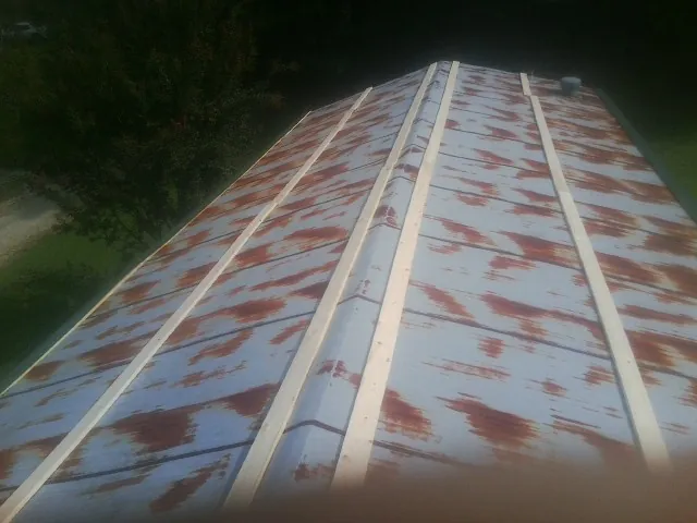 Rusted metal roof panels with new wood purlins before replacement — Storm Damage Roof Repair in Dearing by Roofing Brothers