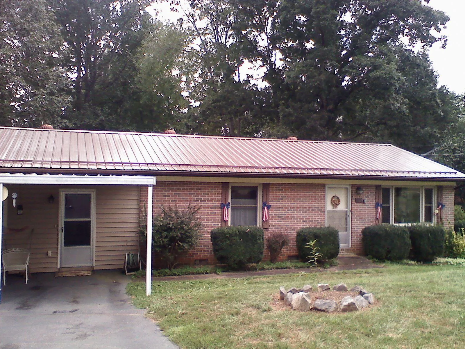 Bronze metal roof and carport on a brick ranch home — Roof Repair work by our crew in Dearing